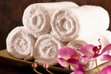 Five rolled towels with an orchid for decoration in a spa setting